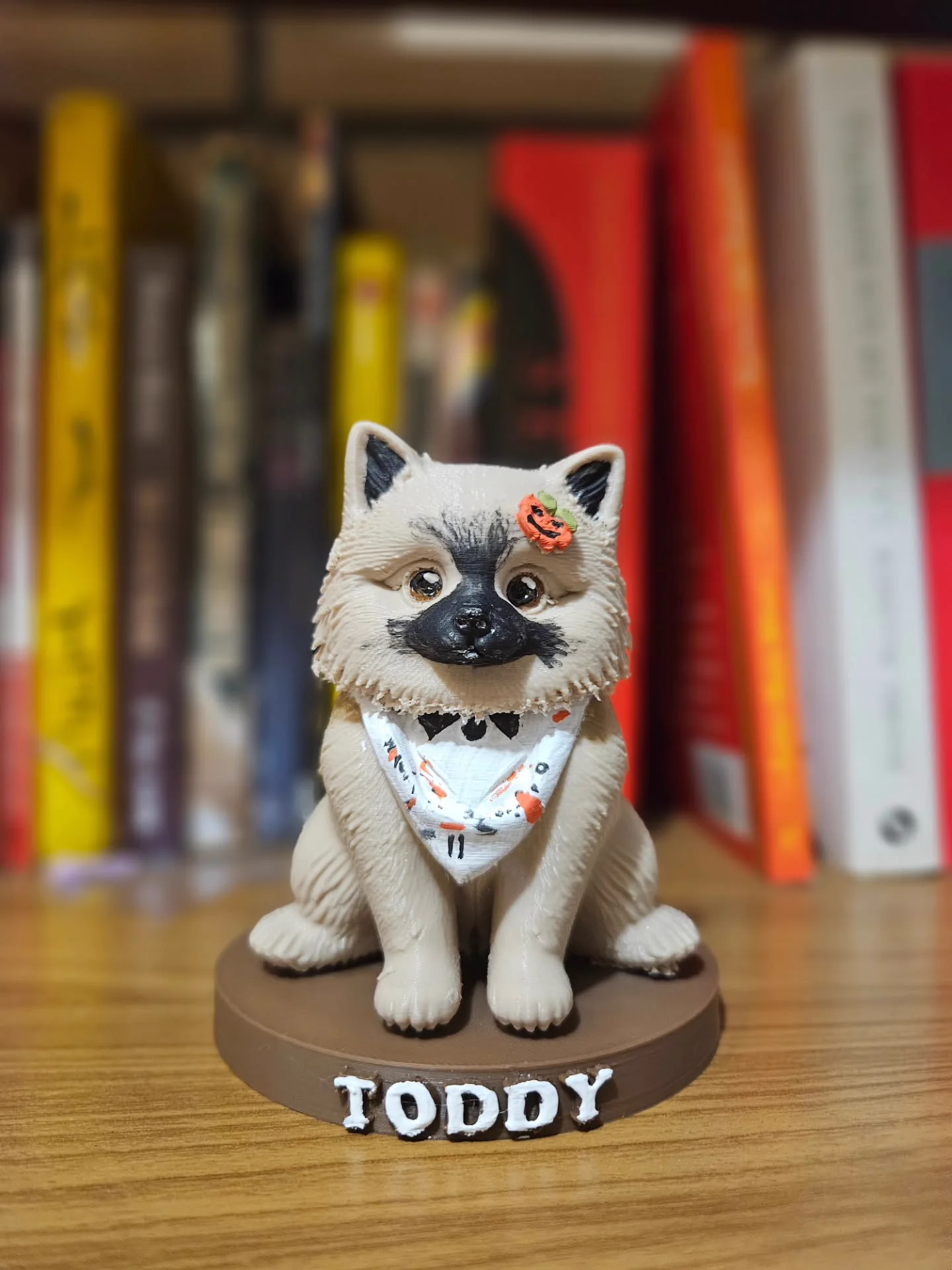 Miniatura do cachorro Toddy sobre base com seu nome, em uma mesa